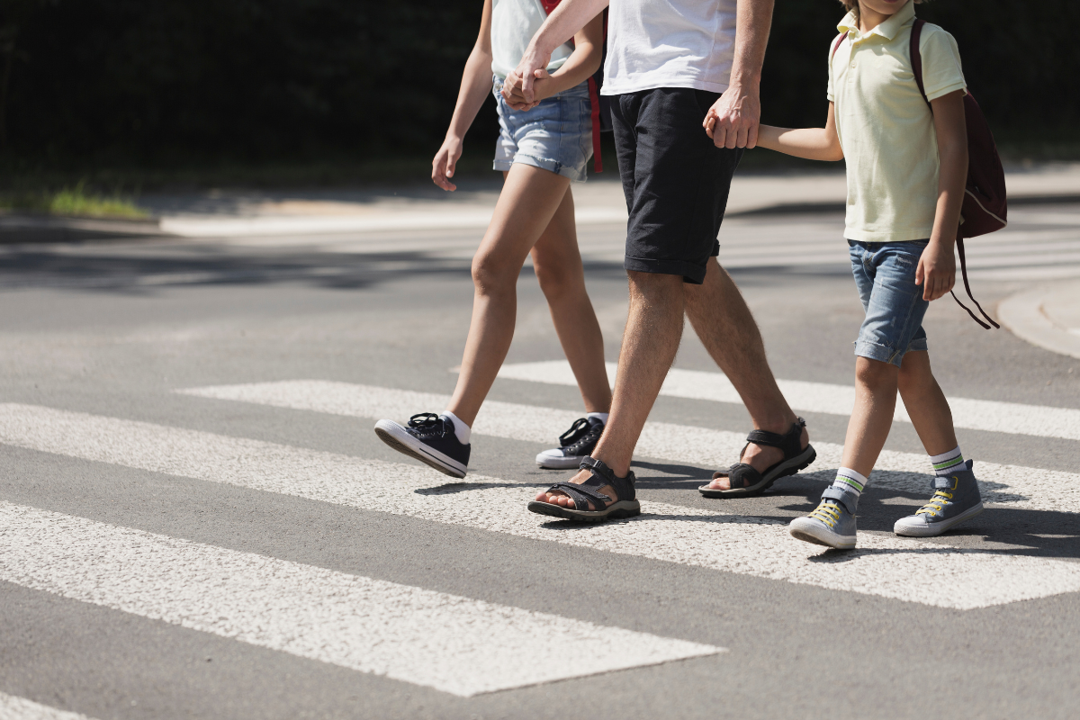 three pedestrians crossing the road safetly